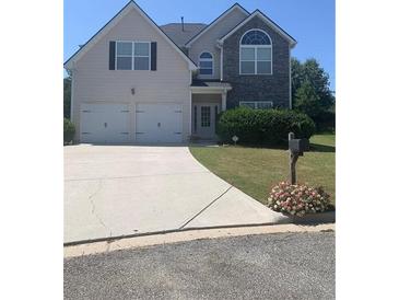 Charming two-story home featuring a two-car garage, neutral siding and a well-manicured lawn at 2118 Water Mill Ct, Buford, GA 30519