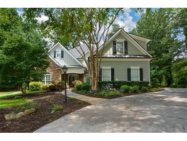 Charming home featuring stone accents, landscaped yard, mature trees, and long driveway at 700 Broadlands Ln, Powder Springs, GA 30127