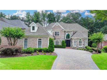 Stunning brick home with manicured landscaping and a beautiful stone driveway at 8230 Royal Melbourne Way, Duluth, GA 30097