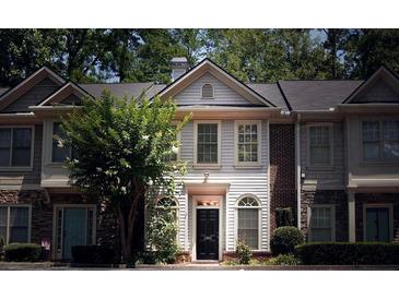 Charming townhome with manicured landscaping and a welcoming front entrance with sidelight windows at 1282 Harris Commons Pl, Roswell, GA 30076