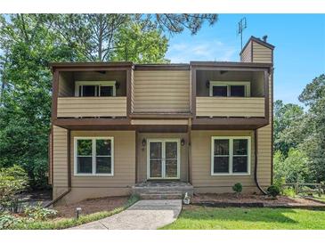Charming two-story home featuring a covered entry and twin balconies with verdant lawn and mature tree surround at 3611 Winfair Pl, Marietta, GA 30062