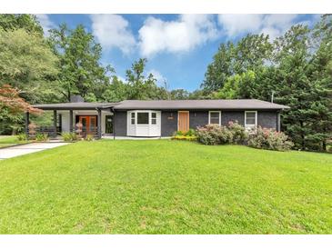 Charming, renovated ranch-style home with a manicured lawn, stylish black brick, and a delightful splash of color on the front door at 851 Flagler Se Cir, Smyrna, GA 30080