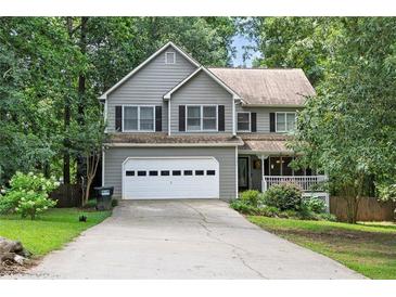 Traditional two-story home with a two-car garage, mature trees and an inviting front porch at 131 Banyon Ct, Dallas, GA 30157