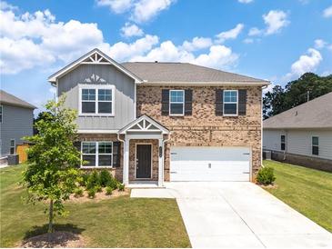 Charming two-story brick home with a well-manicured front yard and attached two-car garage at 3660 Cattle Field Xing, Loganville, GA 30052
