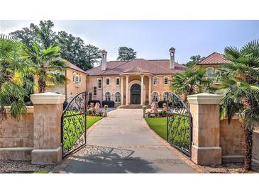 Elegant Mediterranean-style estate with wrought iron gate and lush landscaping at 720 Heards Ferry Rd, Sandy Springs, GA 30328