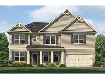 Charming two-story home featuring symmetrical design elements, a well-manicured lawn, and an attached two-car garage at 1816 Kingsmere Run Dr, Loganville, GA 30052