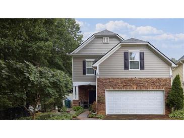 Charming two-story home features stone accents, a two-car garage, and a well-maintained front yard at 2468 Whistle Stop Dr, Norcross, GA 30071