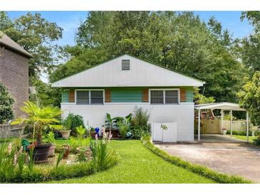 Charming cottage-style home with a well-manicured front yard, plants, and a carport at 2355 Ewing Ne Dr, Brookhaven, GA 30319