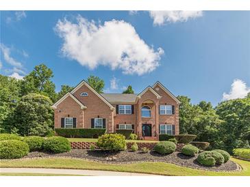 Beautiful brick home featuring mature landscaping and manicured lawn under a bright blue sky at 3202 Lucky Pl, Conyers, GA 30013