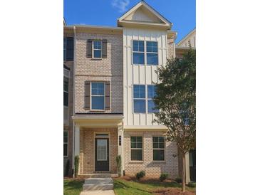 Charming two-story townhome featuring a brick facade, large windows, and a well-maintained lawn at 537 Fundao Ln, Lawrenceville, GA 30046