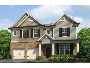 Charming two-story home with a brick and siding exterior, complemented by a well-manicured lawn and flowerbeds at 1797 Kingsmere Run Dr, Loganville, GA 30052