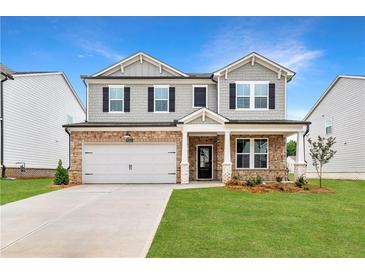 Charming two-story home with stone accents, attached garage, and a beautifully manicured lawn at 722 Crossroad Ct, Powder Springs, GA 30127