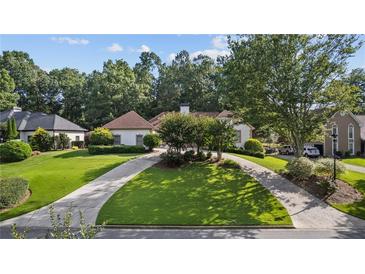 Well maintained front yard with a circular driveway and mature trees at 2050 Trotters Ridge Way, Roswell, GA 30075