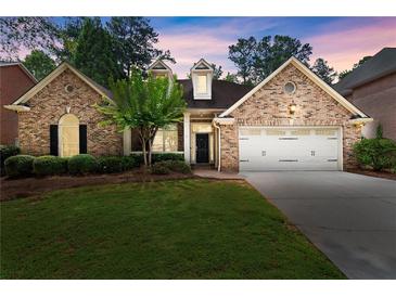 Charming brick home featuring a well-manicured lawn and a two-car garage in a desirable neighborhood at 1065 Beacon Hill Xing, Alpharetta, GA 30005