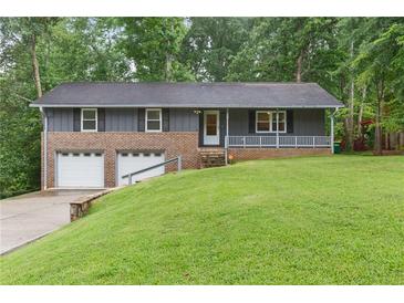 Charming home featuring a brick and siding exterior, a well-manicured lawn, and an attached two-car garage at 3105 Sumac Dr, Atlanta, GA 30360