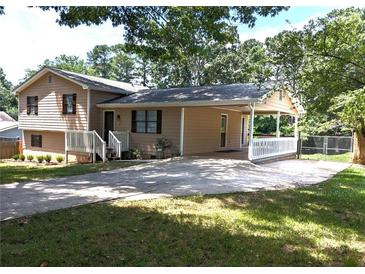 Tan split-level home featuring a covered carport and front porch at 1041 Waverly Drive Dr, Lawrenceville, GA 30046
