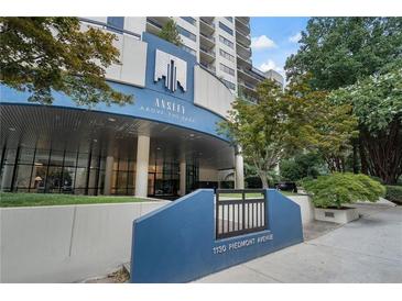 Upscale condo building entrance with manicured landscaping and prominent signage at 1130 Piedmont Ne Ave # 404, Atlanta, GA 30309