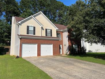 Two-story home with a brick facade, attached two-car garage, and driveway at 455 Crafton Ct, Lawrenceville, GA 30043