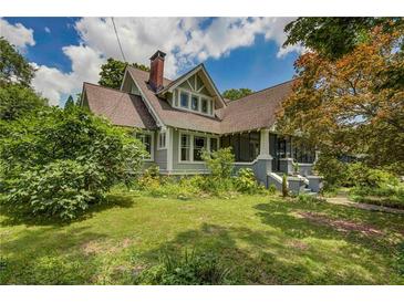 Charming two-story home with a gabled roof, brick chimney, and lush landscaping in a suburban setting at 222 Winonna Dr, Decatur, GA 30030
