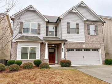 Charming two-story home featuring a gray exterior, brick accents, attached two-car garage and manicured landscaping at 1264 Brynhill Ct, Buford, GA 30518