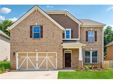 Inviting two-story brick home with a two-car garage and manicured lawn at 5430 Breckinridge Ln, Cumming, GA 30040
