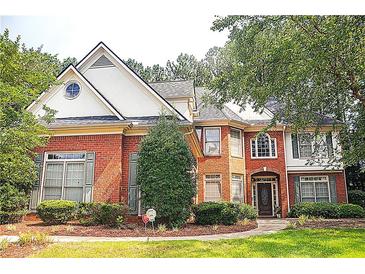 Beautiful brick two-story home with a manicured lawn and mature trees at 555 Stoneglen Sw, Atlanta, GA 30331