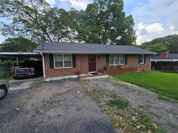 Charming one-story brick home with green shutters, well-manicured lawn and a convenient carport at 1763 Sandtown Sw Rd, Marietta, GA 30060