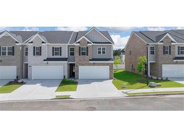Charming townhome exteriors with brick and gray siding, featuring attached garages and well-maintained landscaping at 205 Silver Moon Dr, Loganville, GA 30052