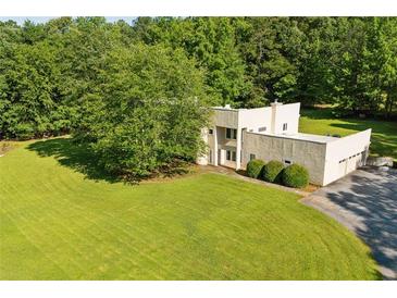 Unique home boasting a lush green lawn, mature trees, and a multi-car garage at 110 Bridger Point Rd, Fayetteville, GA 30215