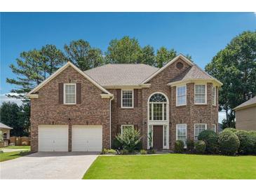 Charming two-story brick home featuring a manicured lawn, two-car garage, and large arched entryway at 775 Gran Heritage Way, Dacula, GA 30019