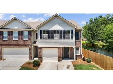 Charming two-story townhome features a well-kept front yard and a one-car garage at 173 Oakland Hills Way, Lawrenceville, GA 30044