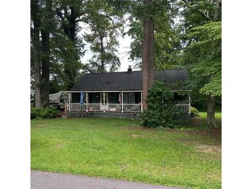 Charming single-story home featuring a cozy covered porch and a lush green front lawn at 2591 Perkerson Dr, Austell, GA 30168