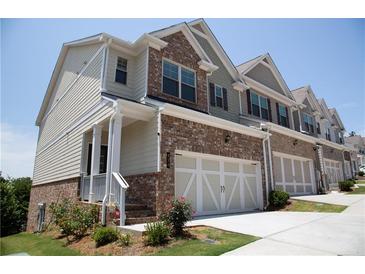 Charming townhome featuring a brick facade and a two-car garage at 339 Cherryhill Ln, Woodstock, GA 30188