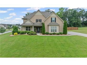 Charming two-story home featuring a well-manicured lawn and beautifully landscaped front yard at 108 Donovan Ave, Locust Grove, GA 30248