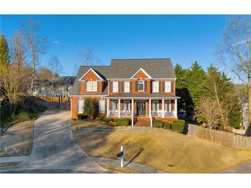 Inviting two-story brick home with a charming front porch and well-manicured landscaping at 4055 Inman Park Ln, Buford, GA 30519