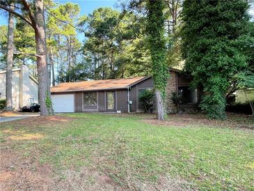 A single story home with brown siding, a stone chimney and a one car garage at 33 Drew Ct, Jonesboro, GA 30238