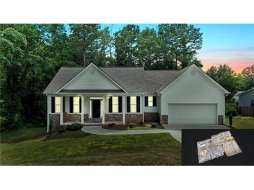 Charming single-story home with white siding, stone accents, well-maintained lawn and attached two car garage at 504 Iris Way, Villa Rica, GA 30180