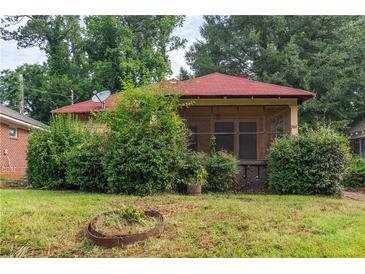 Charming single-story home with a red roof, screened front porch, and mature landscaping at 969 Byron Sw Dr, Atlanta, GA 30310