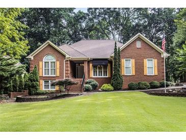 Charming brick home with manicured lawn, mature trees, and yellow shutters at 2525 Fairview Dr, Cumming, GA 30041