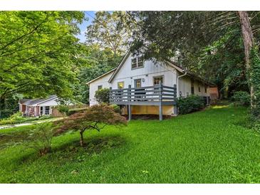 Charming house with a deck and lush green lawn surrounded by mature trees at 6719 Sunset Valley Cir, Rex, GA 30273