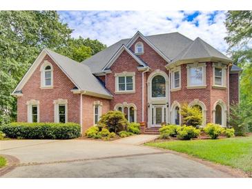 Stately brick home with manicured landscaping and a circular driveway at 1350 Whitley Rd, Dacula, GA 30019