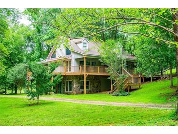 Beautiful home exterior with large deck and lush green lawn, surrounded by mature trees at 1775 Whooping Creek Rd, Carrollton, GA 30116