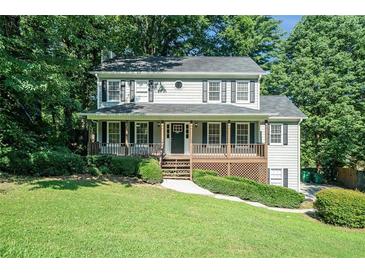 Charming two-story home featuring a covered front porch and lush landscaping at 1107 Leslie Pl, Lithonia, GA 30058