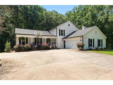 Charming two-story home with a basketball hoop, attached garage and meticulously maintained landscaping at 12550 Hutcheson Ferry Rd, Palmetto, GA 30268