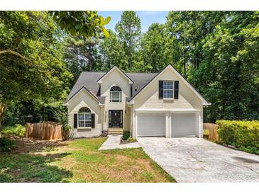 Charming home with a two-car garage, a dark roof, and situated on a wooded lot at 7167 Stonebrook Ln, Lithonia, GA 30058