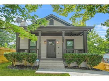 Quaint house featuring a covered front porch with ample seating and manicured shrubs along the walkway at 556 Paines Nw Ave, Atlanta, GA 30318