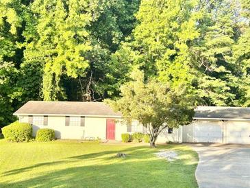 Quaint one-story home with a well-maintained lawn and mature trees for shade and curb appeal at 4363 Stonewall Tell Rd, Atlanta, GA 30349