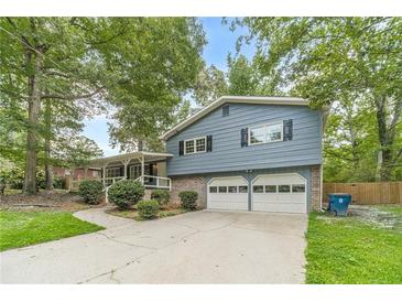 Charming two-story home with blue siding, brick accents, and a two-car garage at 1348 Branchwood Dr, Snellville, GA 30078