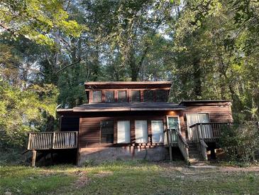Wood cabin-style home with a deck, surrounded by lush trees at 2917 Katherine Valley Rd, Decatur, GA 30032