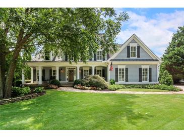 Charming two-story home with a welcoming front porch, lush lawn, and mature landscaping at 2429 Kirk Nw Ln, Kennesaw, GA 30152